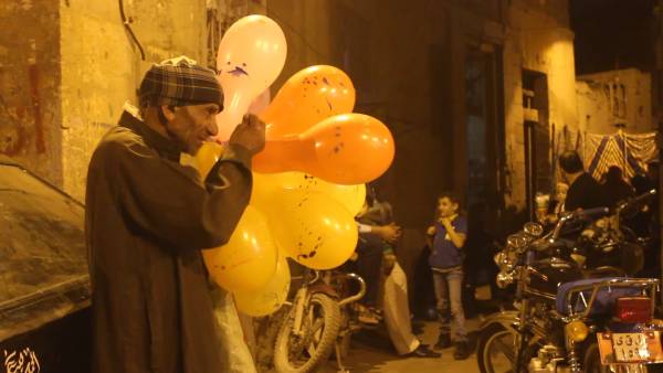 Elderly Man Blowing and Selling Balloons to Children in Cairo, Egypt – Video