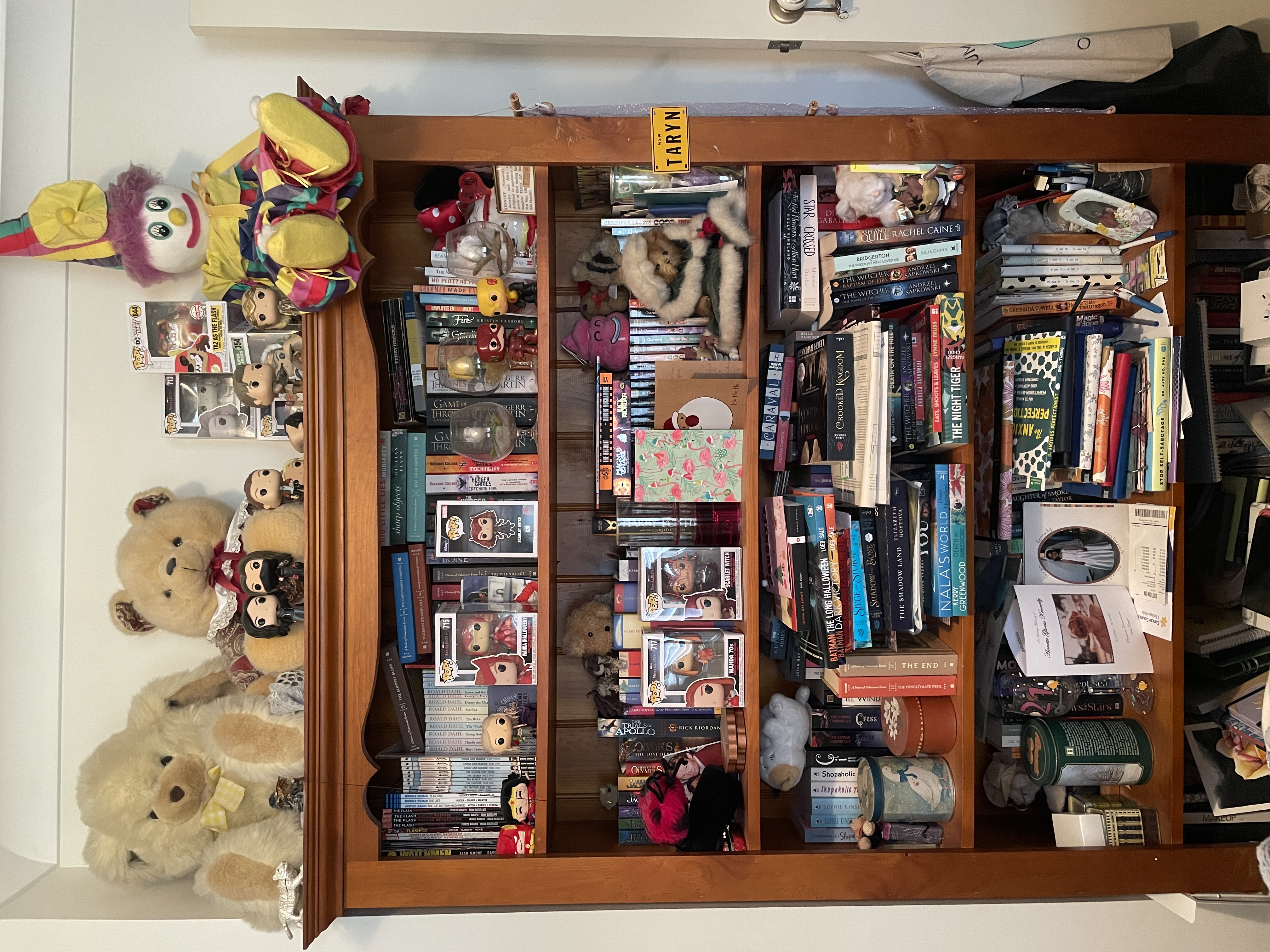 A messy bookshelf of four shelves.