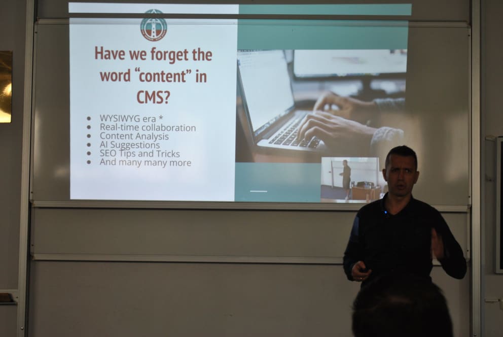 A presenter stands in front of a slide titled "Have we forget the word 'content' in CMS?" listing features like real-time collaboration and AI suggestions.