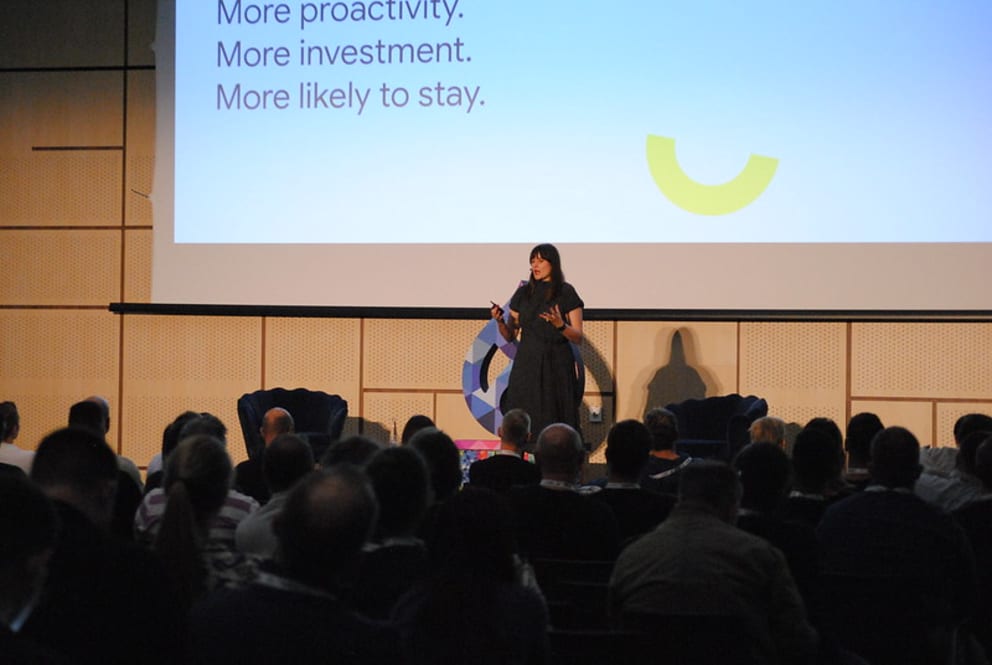 Women dressed in black giving a talk at a conference