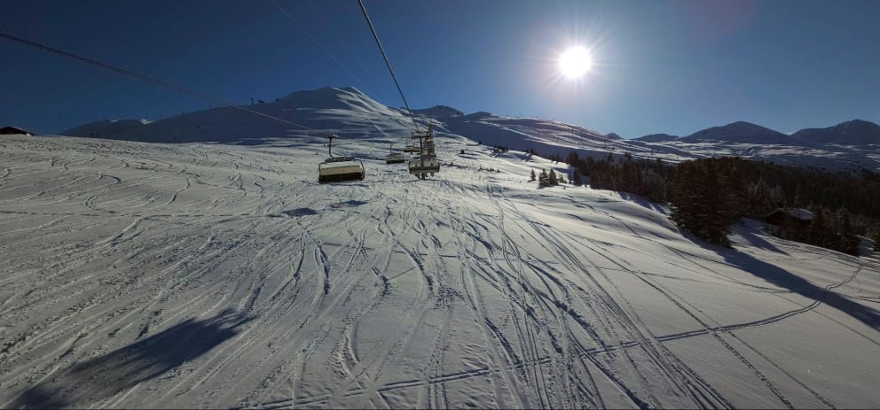 Sunny view of the tracked out off-piste area of Davos Jakobshorn taken from the chairlift