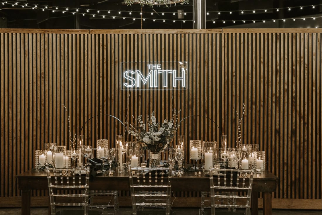 A long dinner table set in front of the Smith & Co. sign