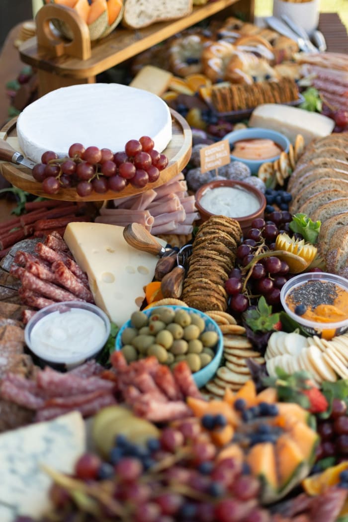 A grazing spread of cheeses, meats, and fruit
