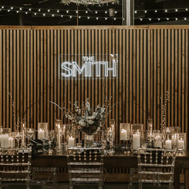 A long dinner table set in front of the Smith & Co. sign