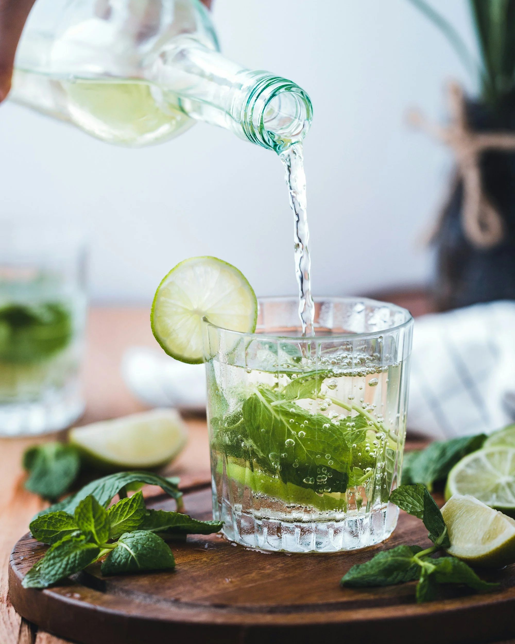 Pouring a cocktail garnished with mint