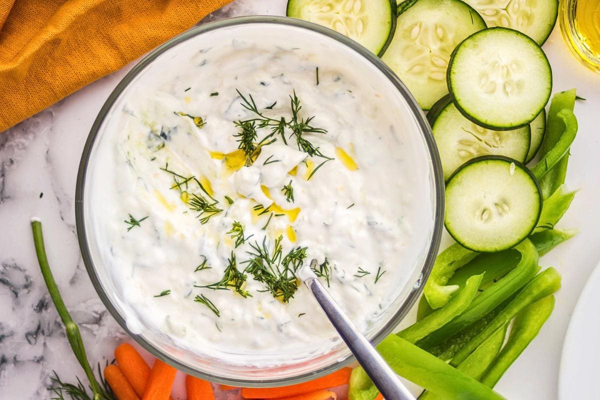 Creamy Greek tzatziki sauce in a bowl with cucumber and dill garnish.