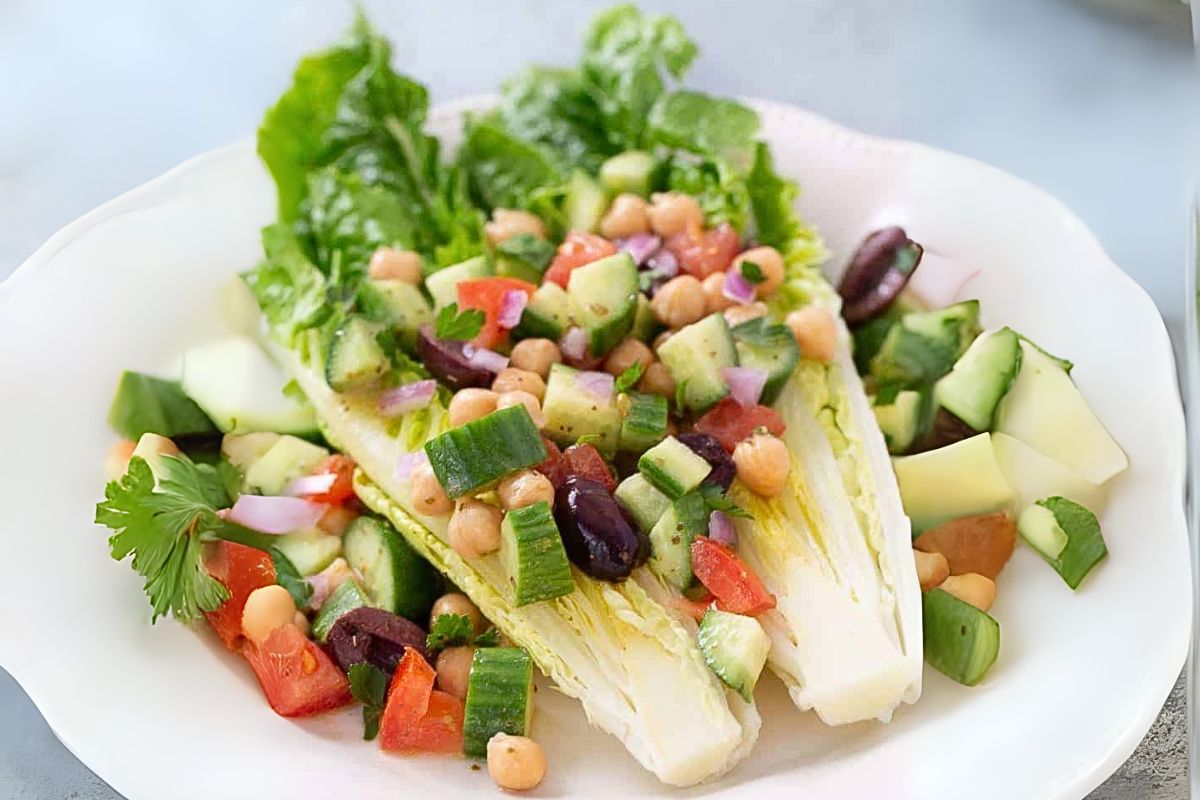 A crisp Greek wedge salad topped with olives, cucumbers, tomatoes, and feta.