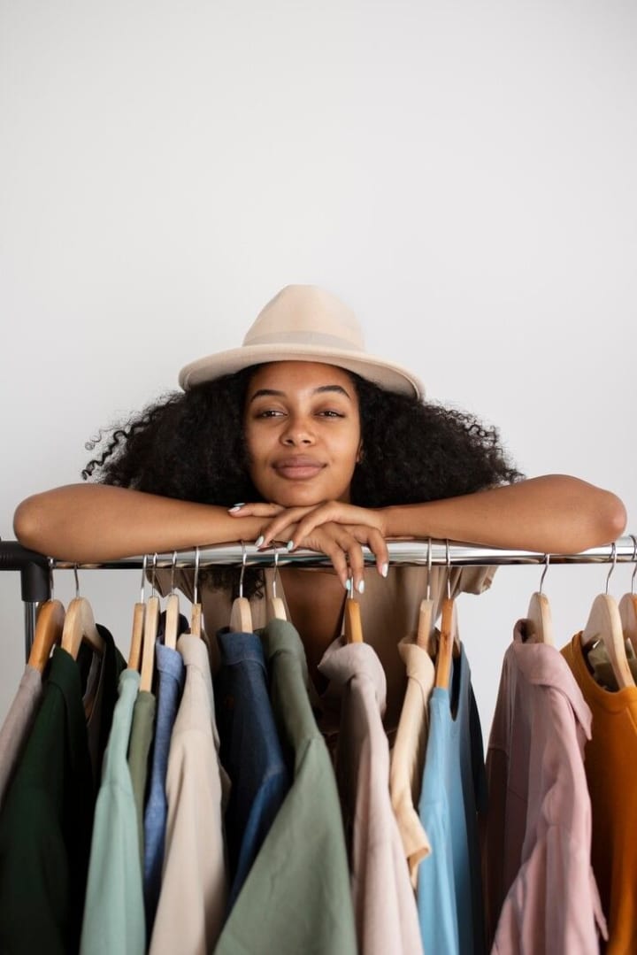 A fashion seller standing behind a clothing rail