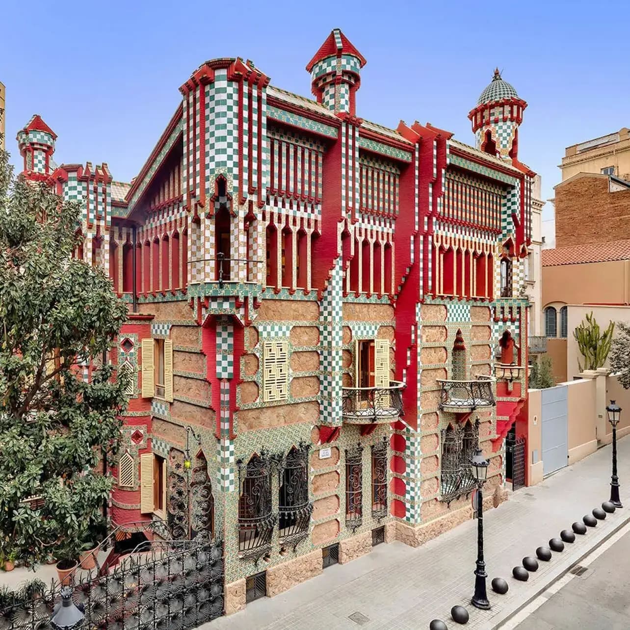 Un edifici acolorit i ornamentat amb patrons d'escacs i detalls intricats, vist des de la cantonada d'un carrer en un dia clar.