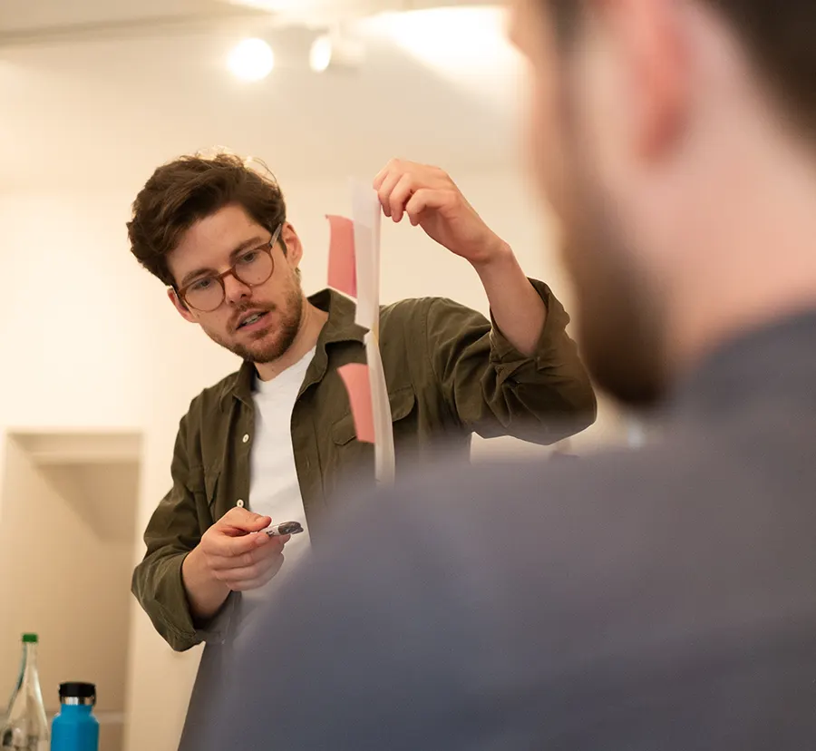Das Foto zeigt den Facilitator im Workshop, während dieser eine Methodik erklärt.