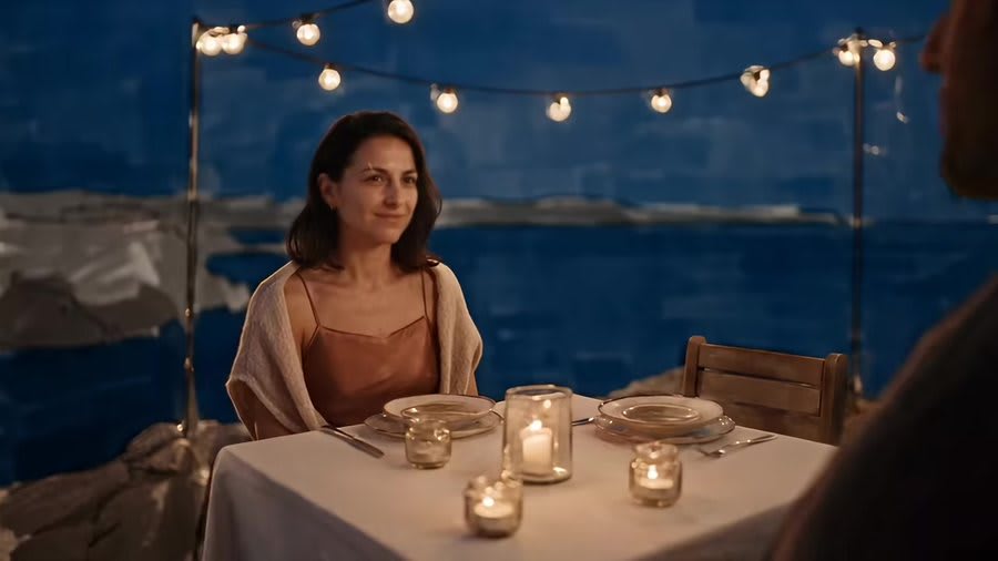 The balcony table at blue hour, with a painted sea behind it.