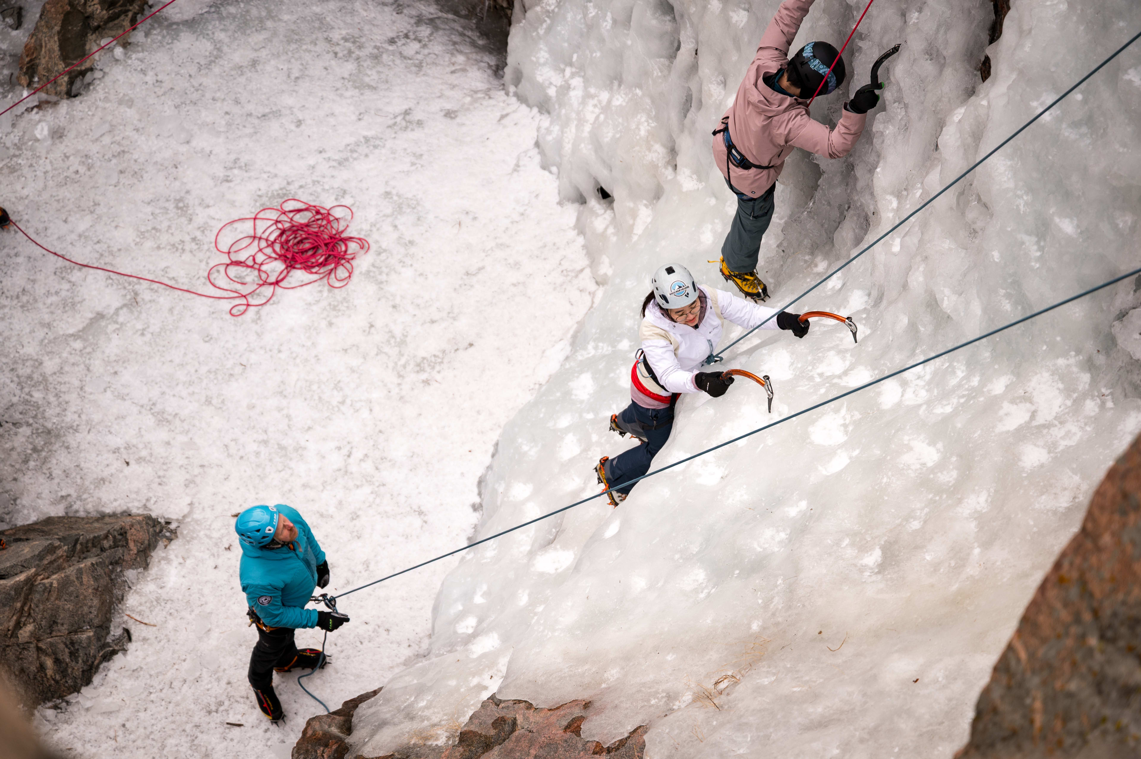 Cruxing in Color ice climbing event — participant climbing