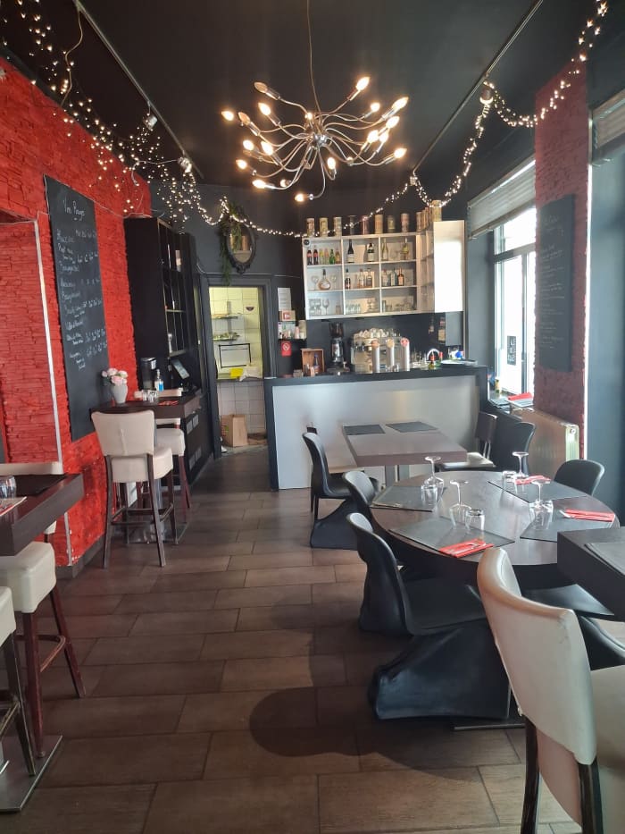 Salle du restaurant Le 17 — mur de briques, lustre moderne, tables dressées