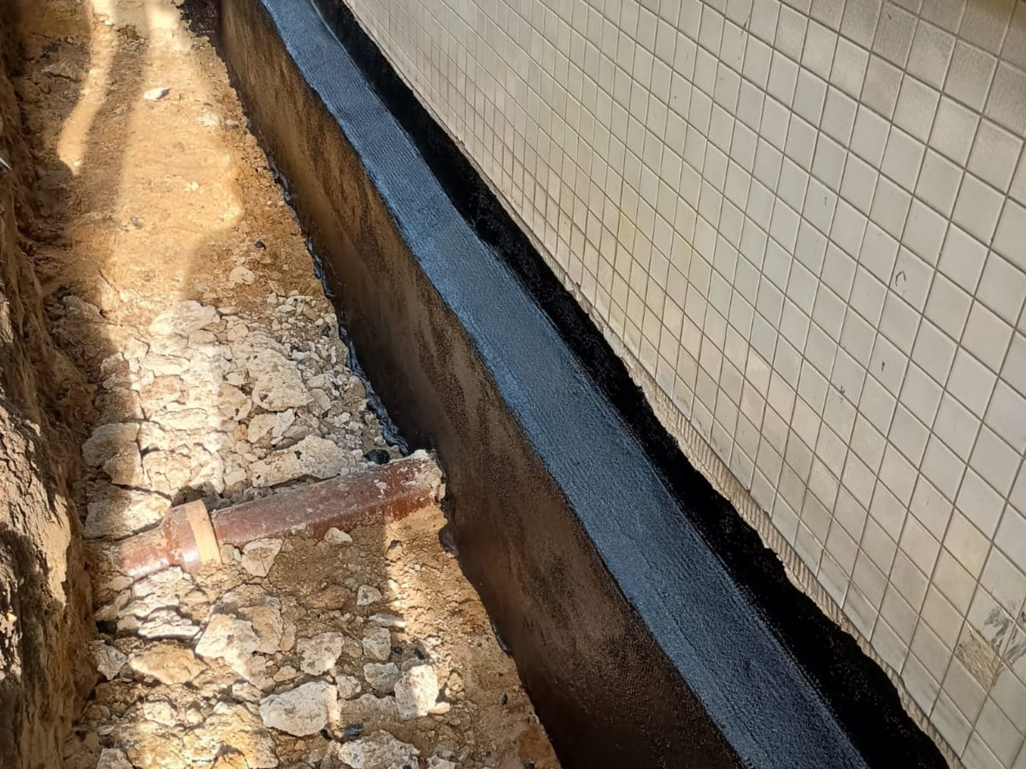 Freigelegte und neu abgedichtete Außenwand eines Gebäudekellers