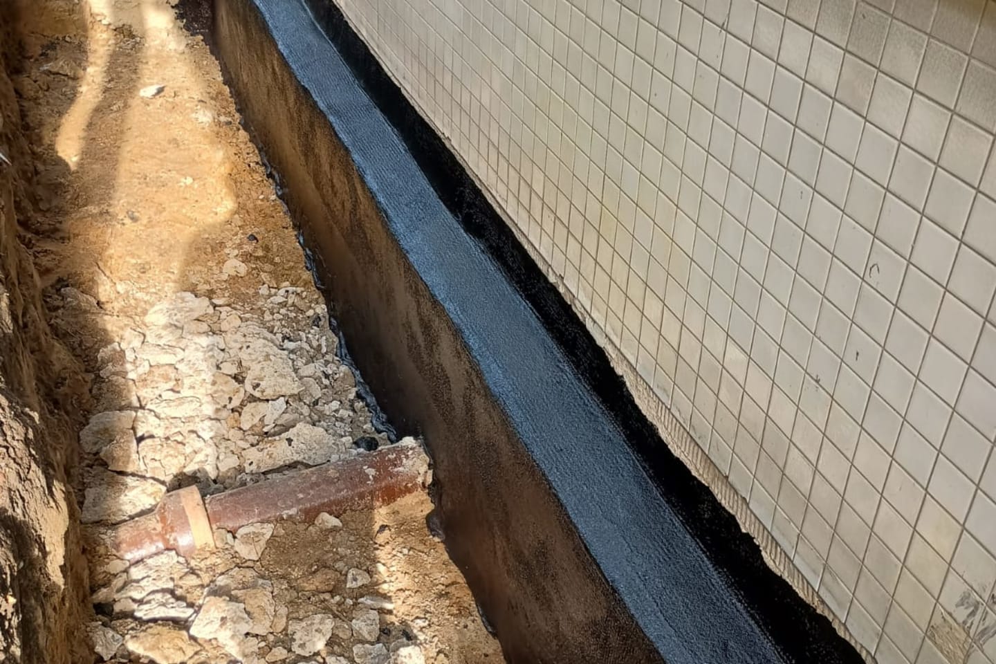 Freigelegte und neu abgedichtete Außenwand eines Gebäudekellers