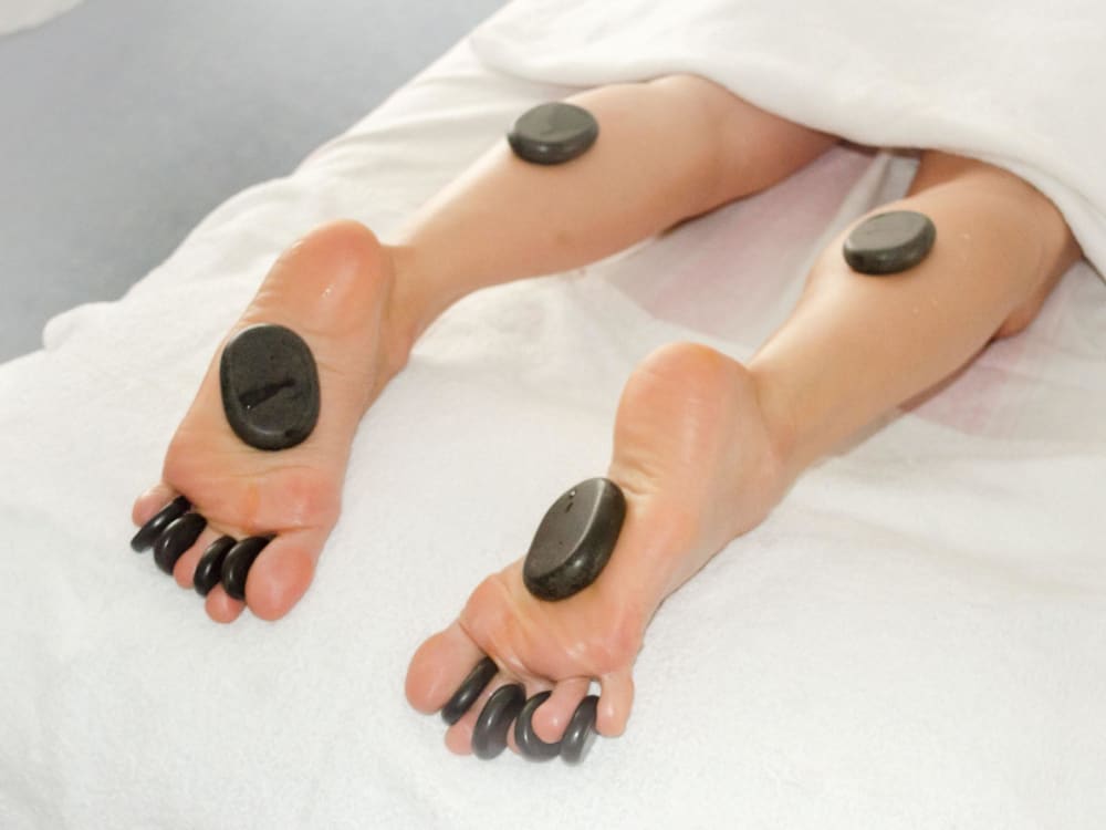 Hot Stone Massage in Norderstedt, warme Basaltsteine werden für die Behandlung aufgelegt