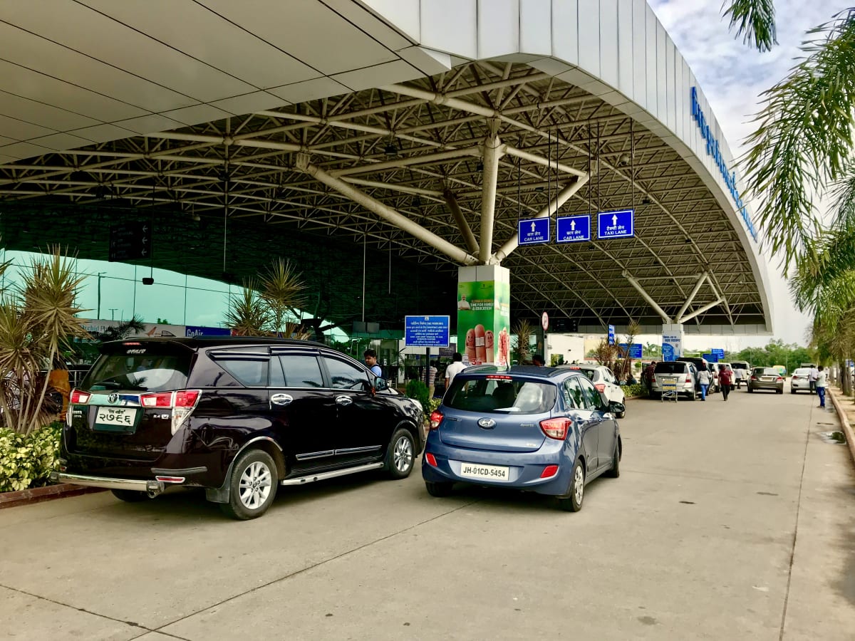 Vehicles outside the Birsa Munda Airport terminal canopy at Ranchi, photographed in July 2018