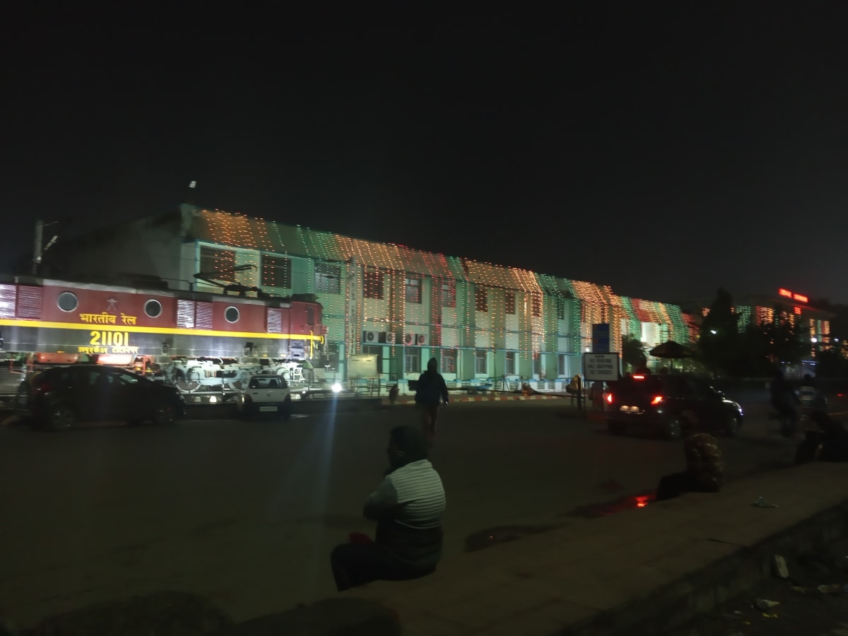 Historic night view of Tatanagar station forecourt with vehicles and a displayed locomotive