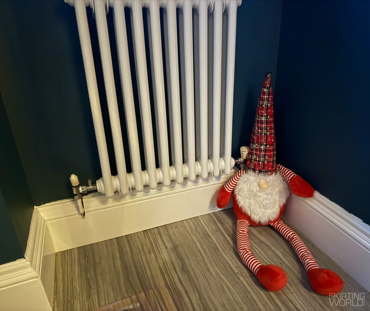 White Antique 1 pine skirting board in a hallway with deep navy walls and timber flooring