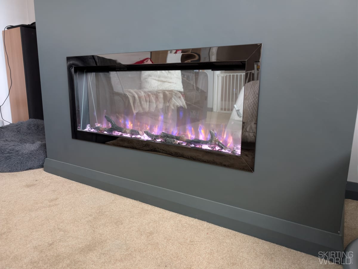 Dark grey Chamfer MDF skirting board painted to match a charcoal fireplace wall in a living room