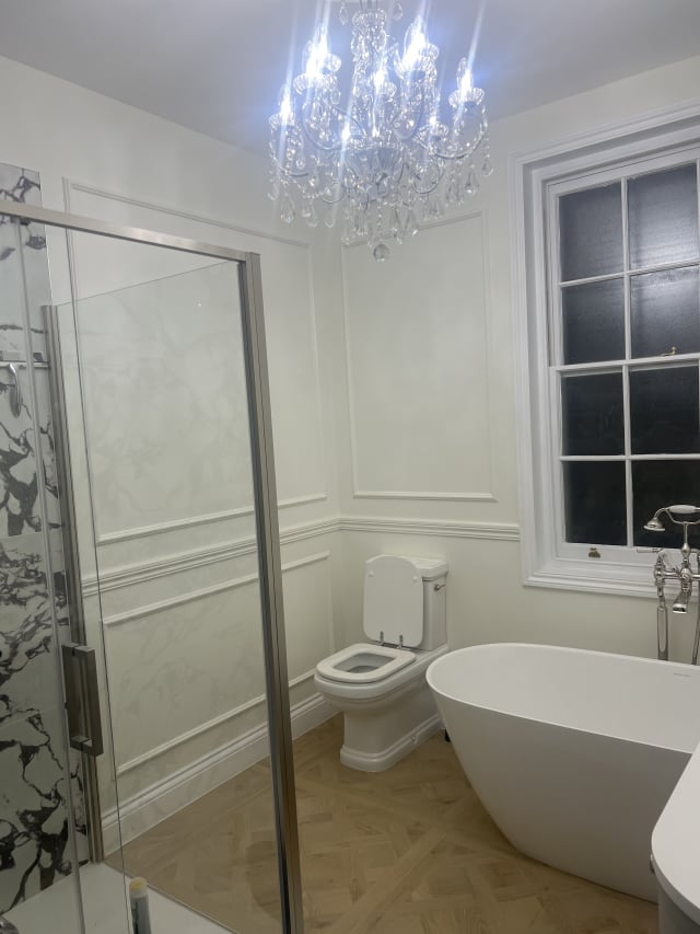 White bathroom wainscoting in Astragal Large panel moulding with an Ogee 2 dado rail, beside a freestanding bath