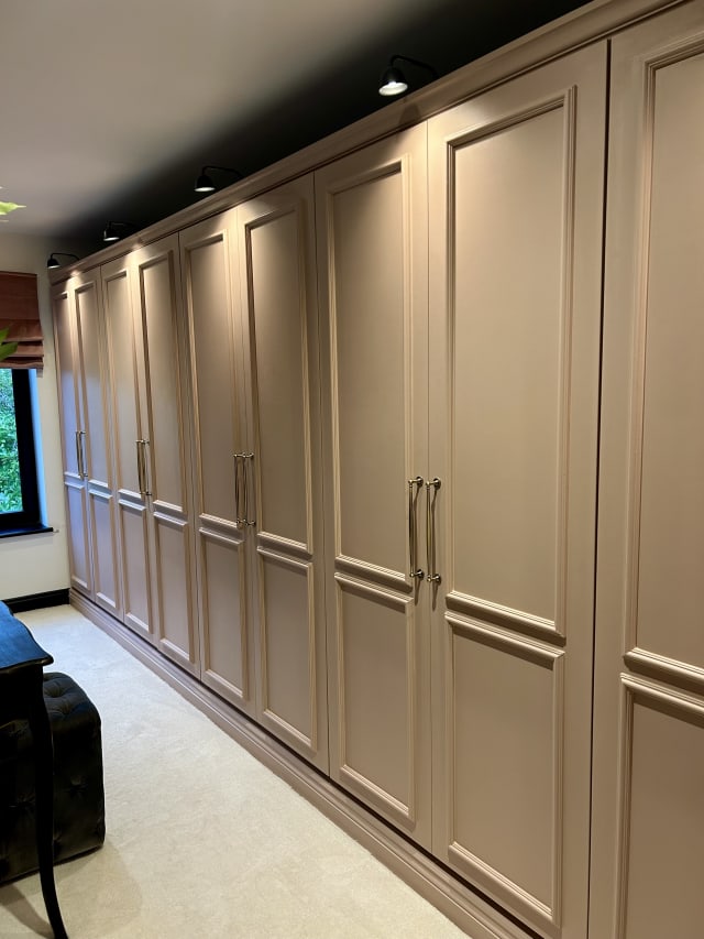 Astragal MDF panel moulding on floor-to-ceiling fitted wardrobe doors, painted soft pink-beige