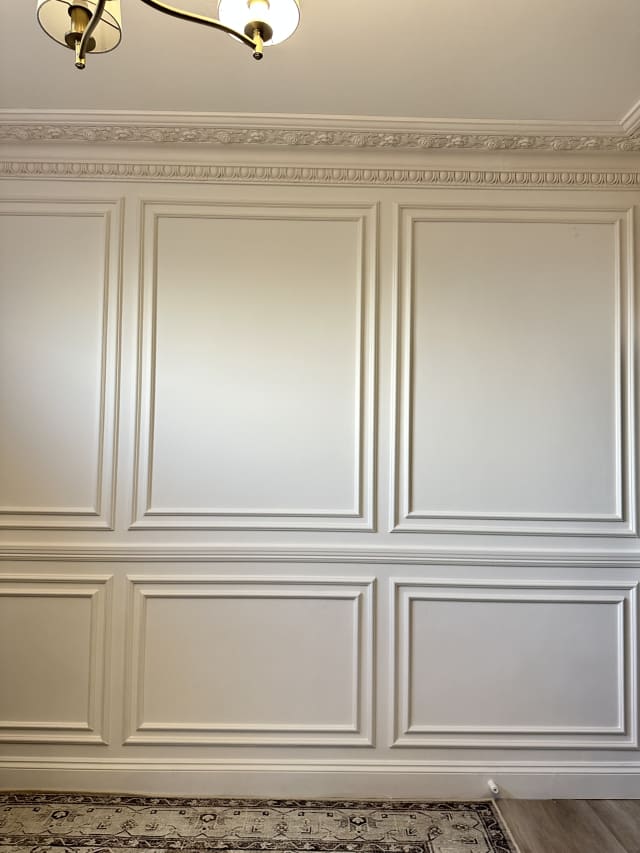 White double-frame wall panelling in Astragal and Astragal Large panel moulding, split by a rail below a cornice