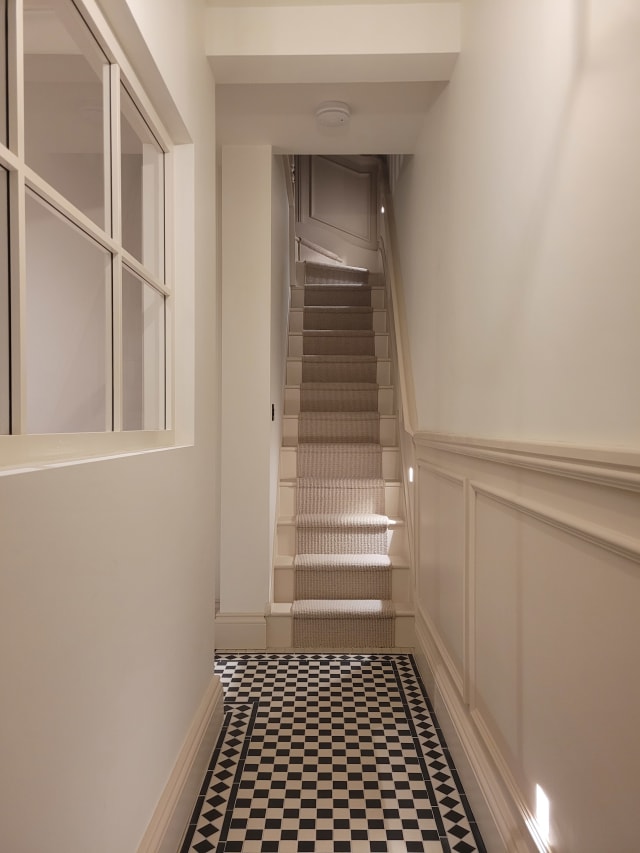 Hallway wainscoting in Astragal and 324 panel moulding with a 324 dado rail, painted cream beside a staircase