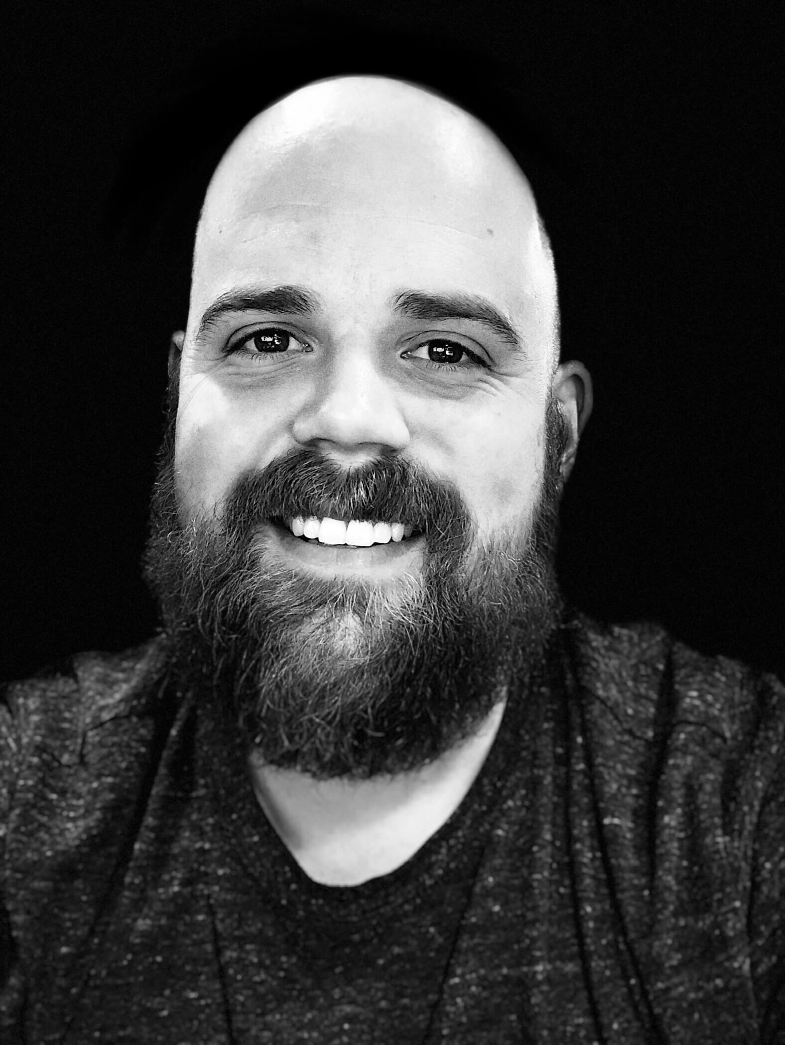 A black and white image of Kenny Howard smiling