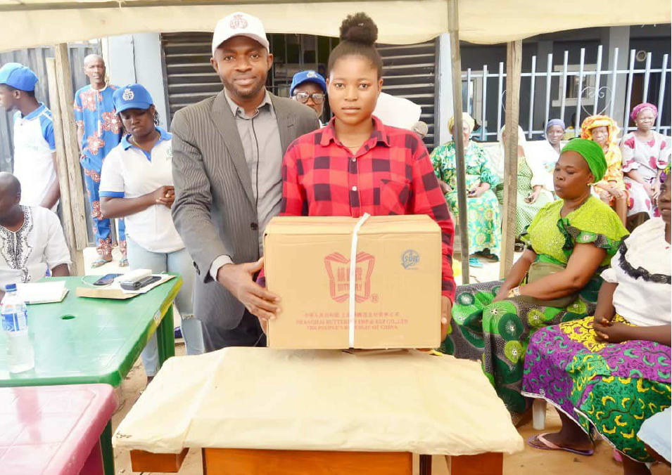 A young woman receiving a carton of food items at the food support drive