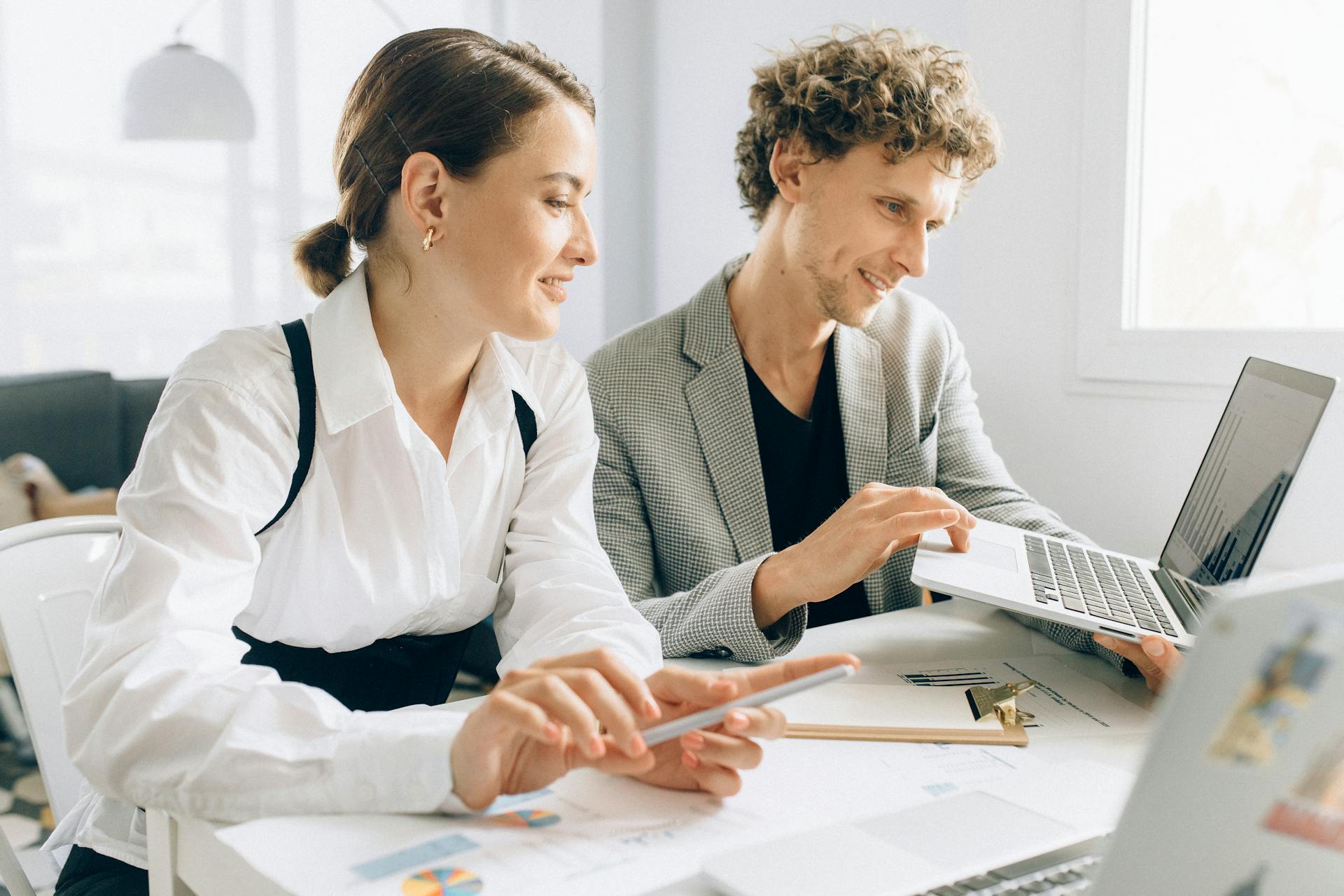 Discovery & Strategy image: a person looking in a laptop screen with co-worker, brainstorming ideas.