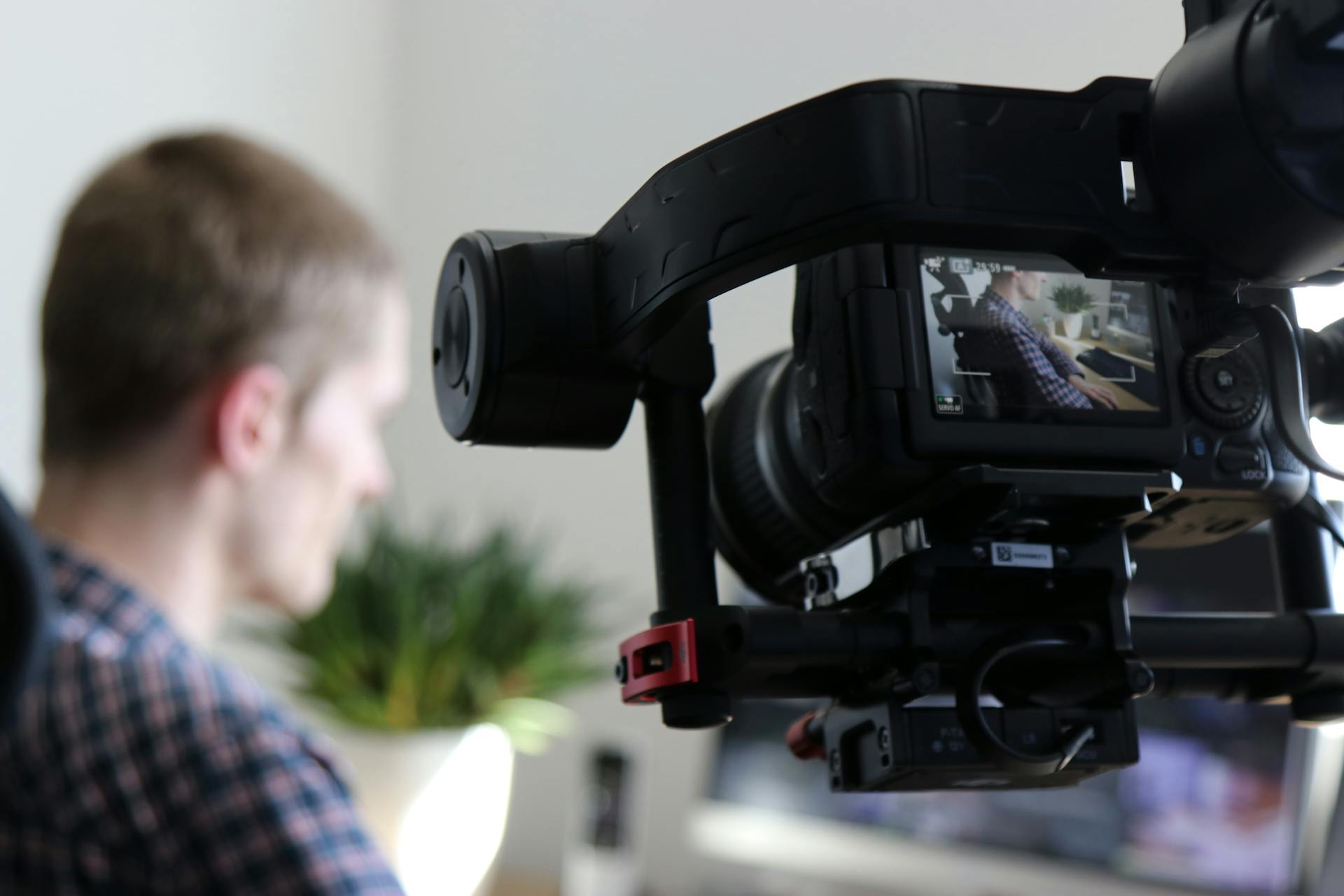 production & development image: a person filming a video with a camera rig, surrounded by lighting equipment.