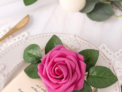 Hot pink artificial rose styled on a wedding place setting