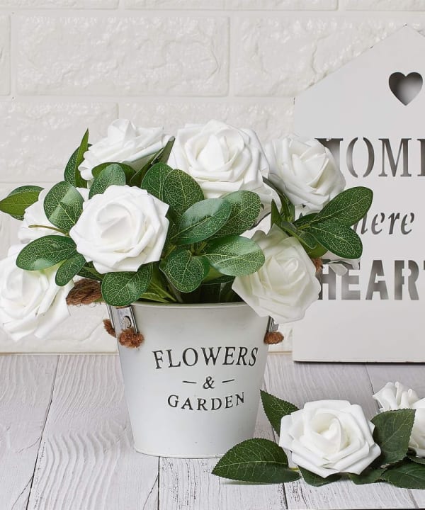 White artificial roses arranged in a planter at home