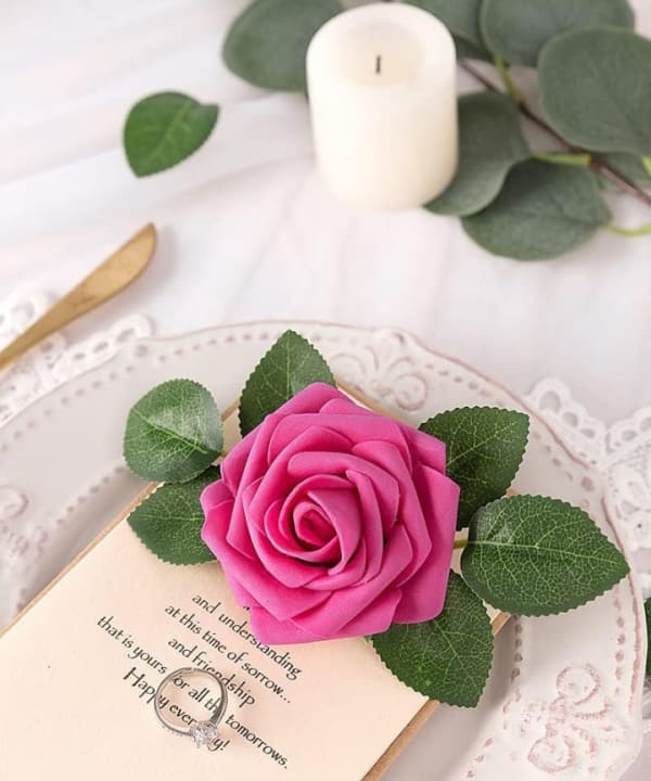 Hot pink artificial rose styled on a wedding place setting