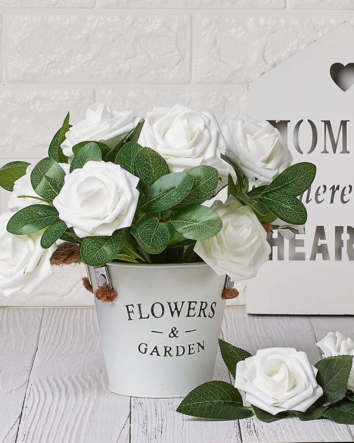 White real-touch foam roses arranged in a home planter