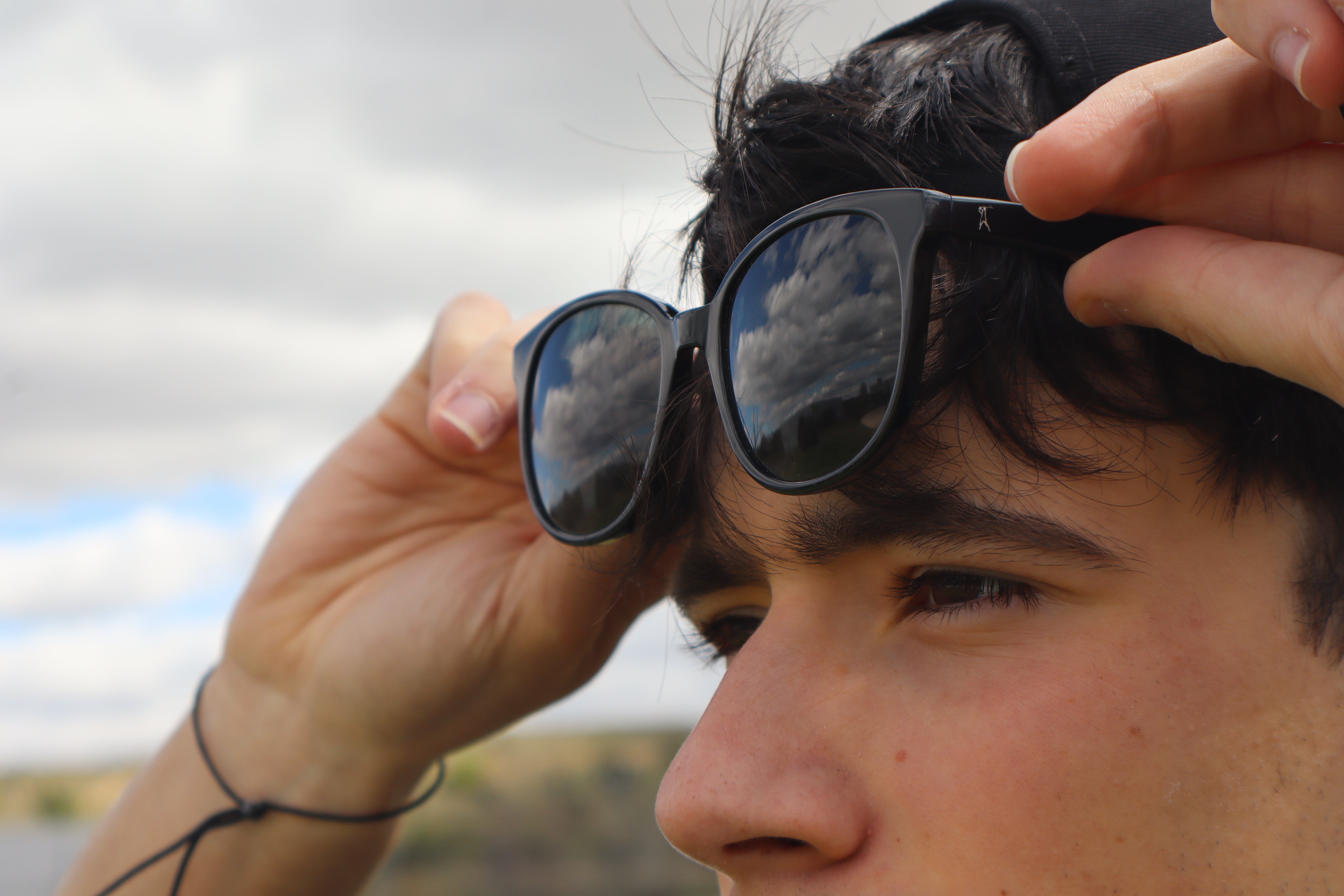 Imagen del proyecto La Mirada, un chico mirando al paisaje levantando sus gafas de sol