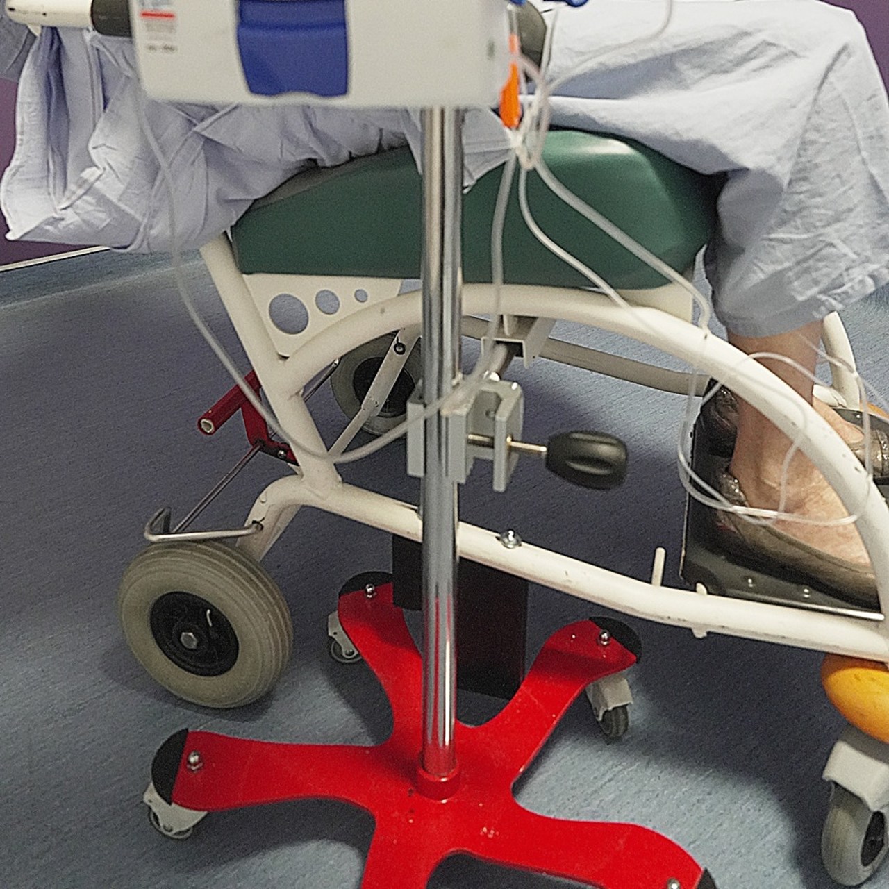 Le dispositif conçu par les brancardiers de Gustave-Roussy comprend une pince fixée sous le fauteuil roulant et qui dépasse légèrement du cadre, si bien que sa tête permet d'arrimer un pied à perfusion et de la stabiliser lors des trajets. (Gustave-Roussy)