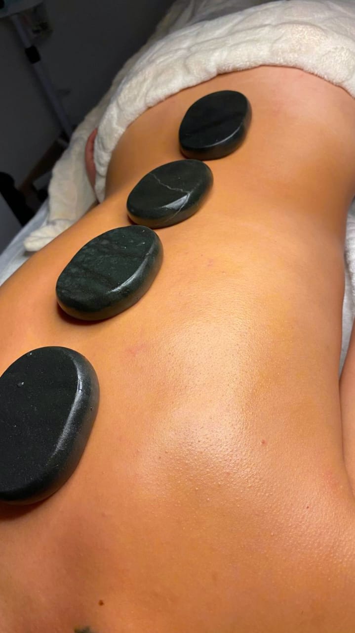 Masaje terapéutico con piedras calientes en la espalda.