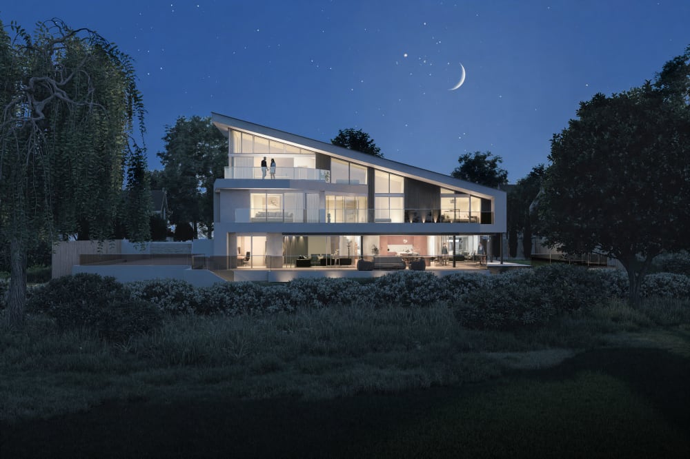 Modern three-story luxury home with floor-to-ceiling windows and angular roofline illuminated at night under starry sky