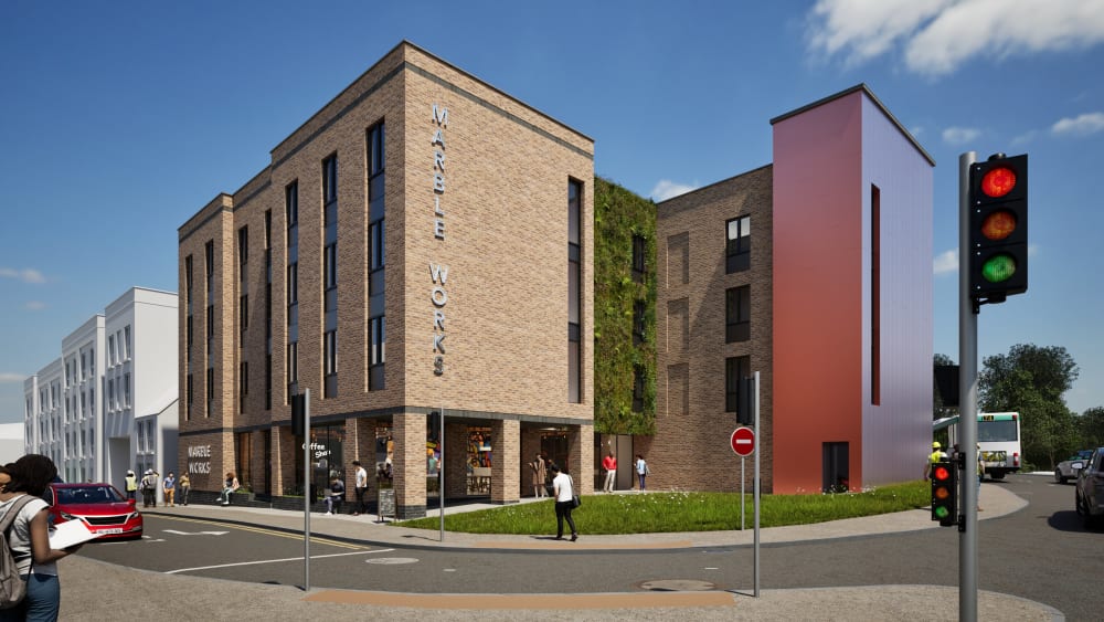Marble Works mixed-use development with brick facade, green living wall, ground floor coffee shop, and modern red accent tower