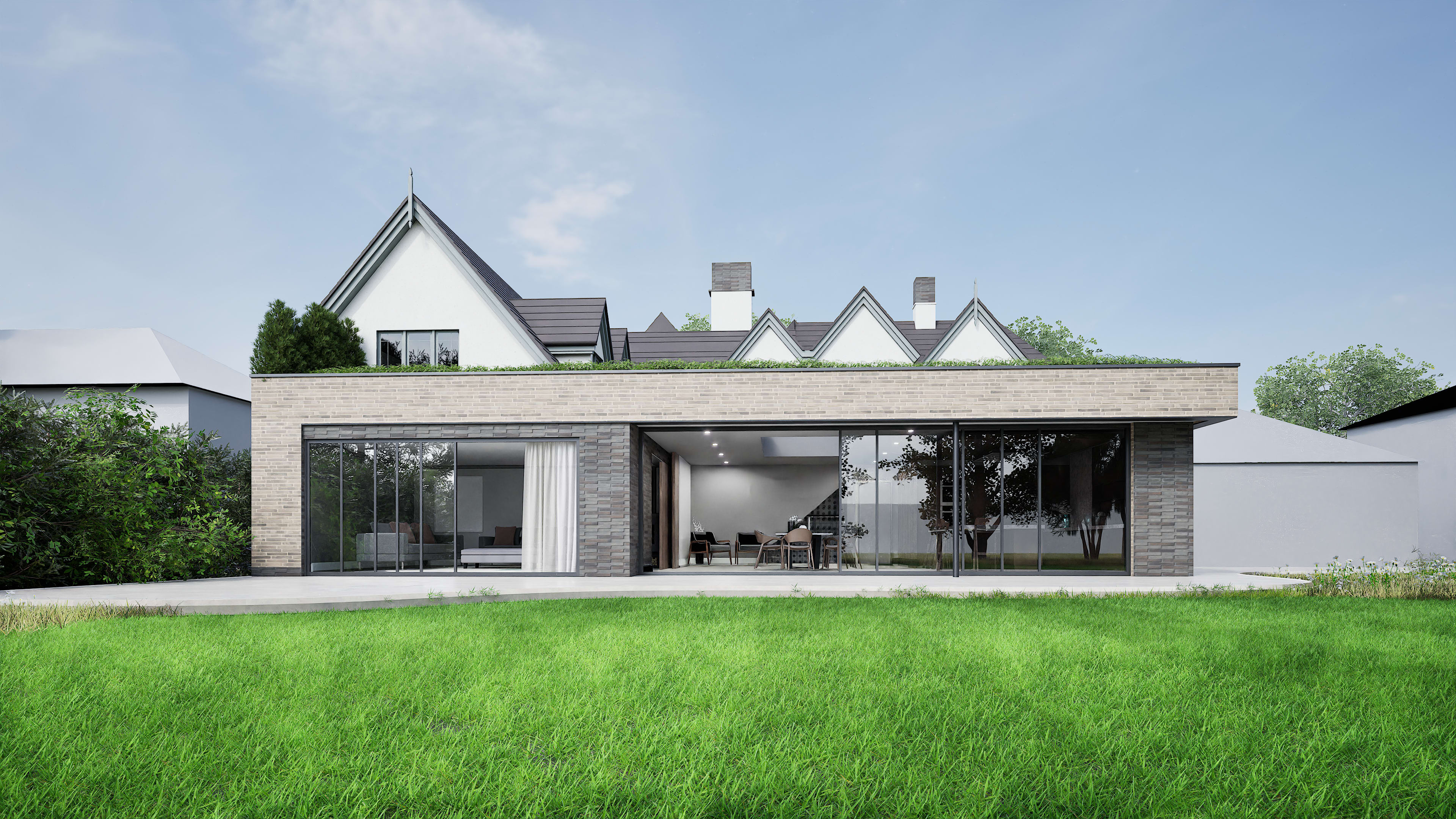 Single-story brick extension with full-height glazing set against a traditional gabled house behind a lawn