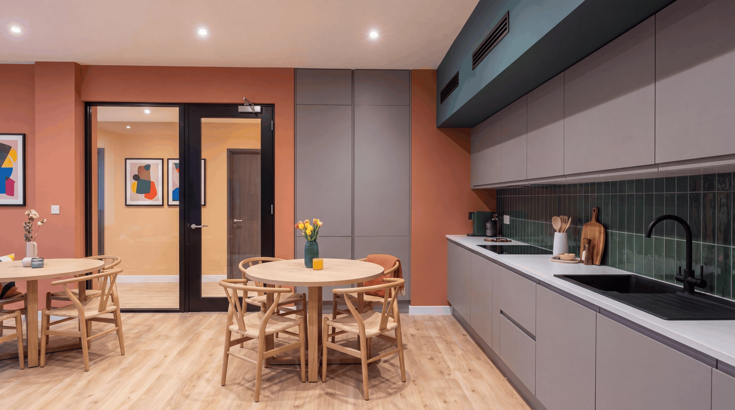 Illustrative visual of the proposed kitchen-diner at Charnwood House, looking through the glazed door and screen into the entrance foyer. Proposed design, not built.