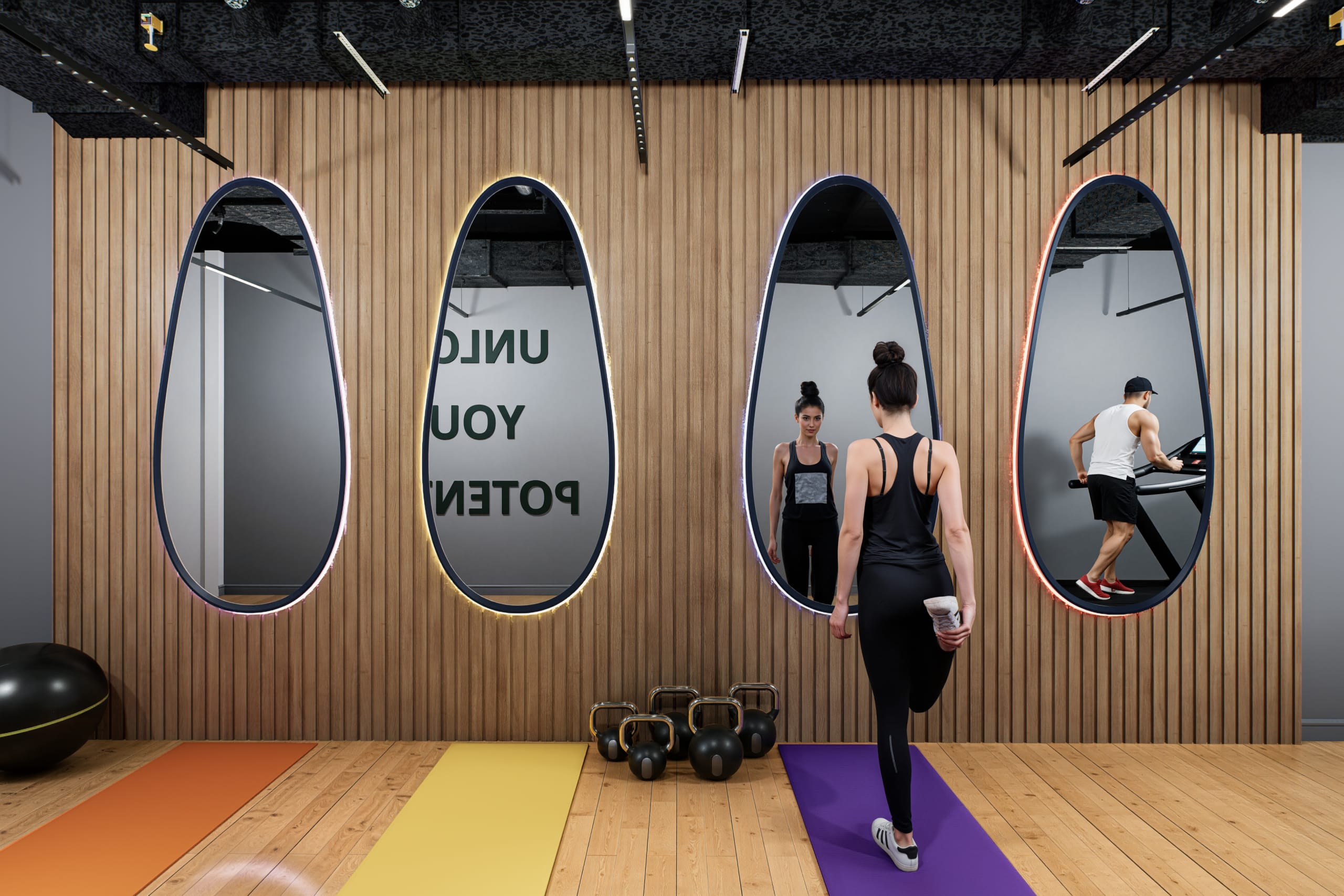 Modern fitness studio with wood slat walls, three oval backlit mirrors, colorful yoga mats, kettlebells, and woman stretching