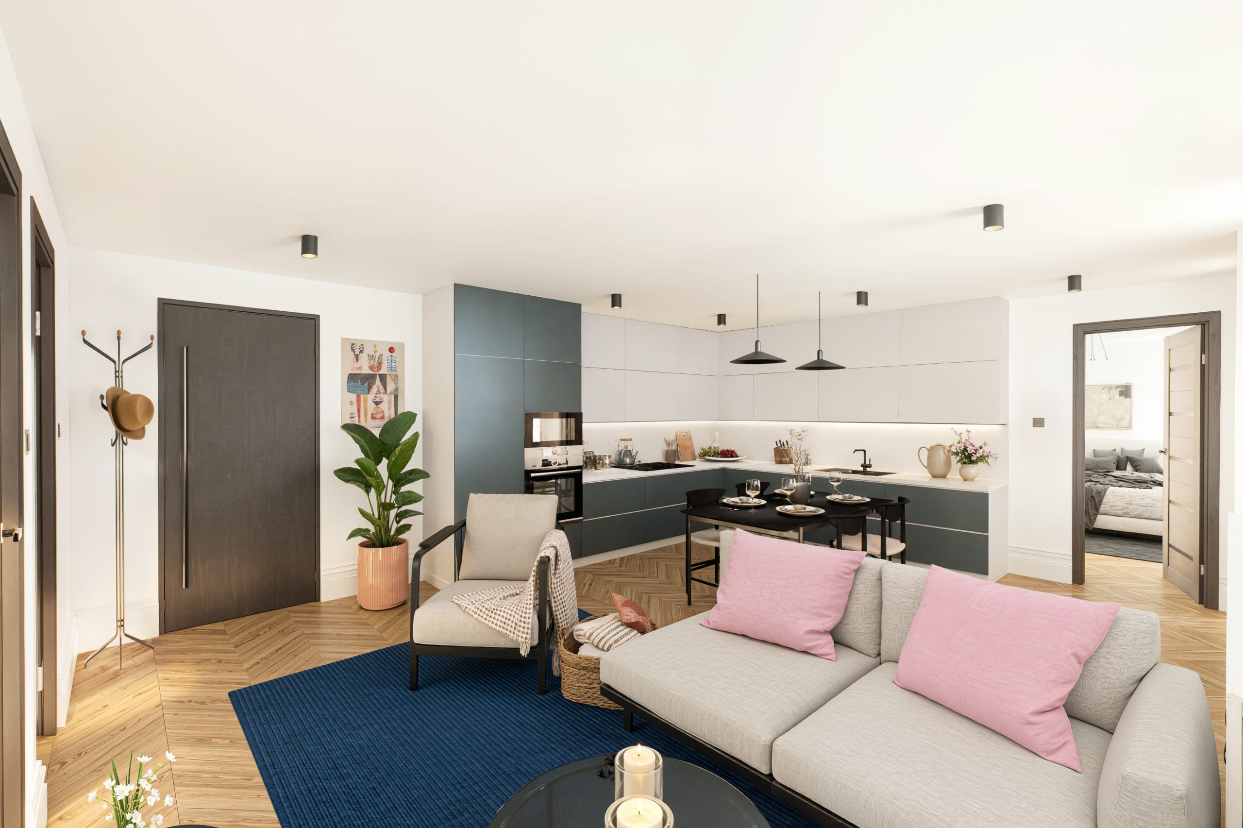 Modern open-plan apartment with grey sofa, pink cushions, blue kitchen cabinets, herringbone wood flooring, and dining area