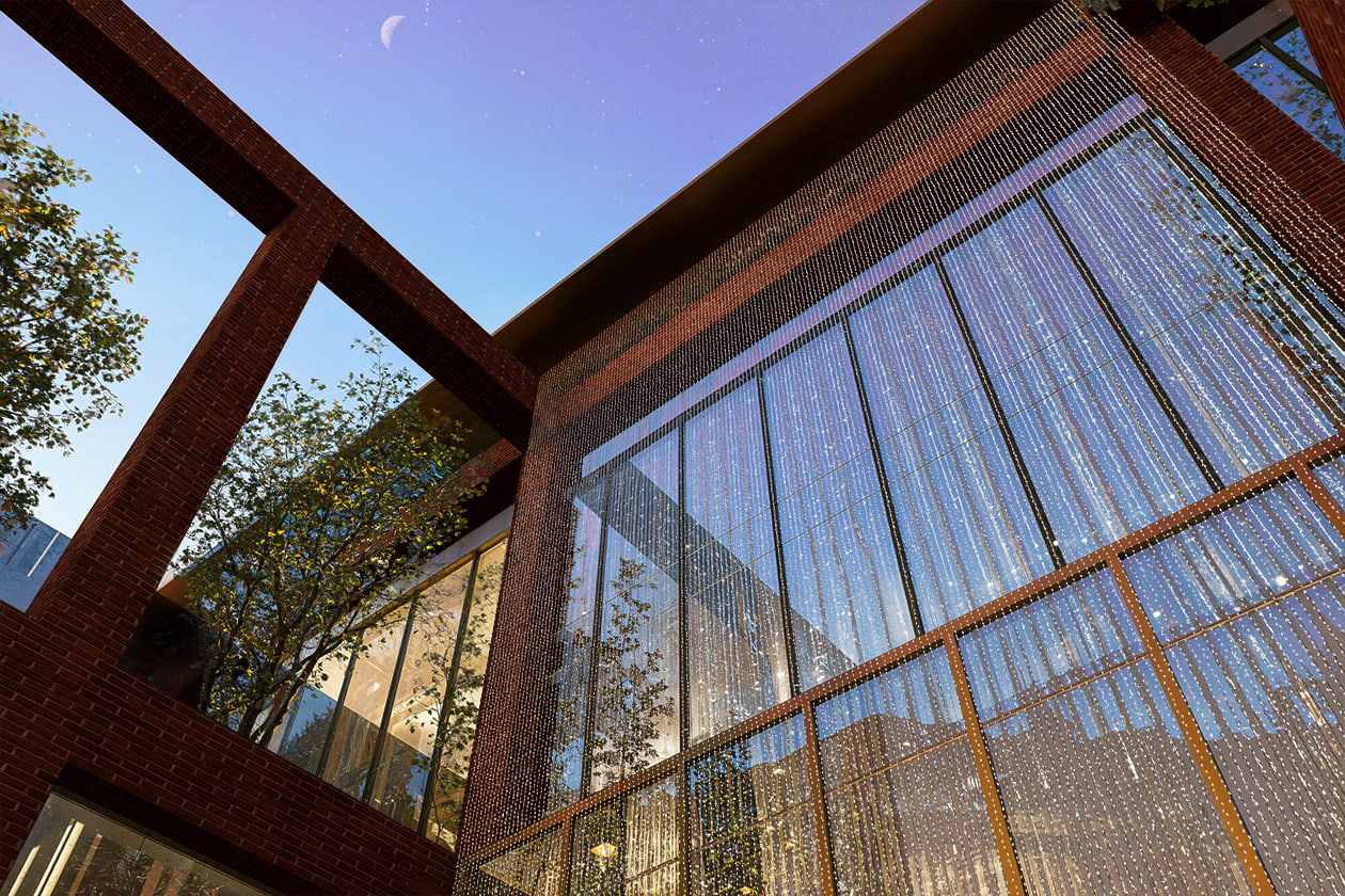 Modern brick and glass building exterior at dusk featuring decorative beaded curtain facade and geometric architectural elements
