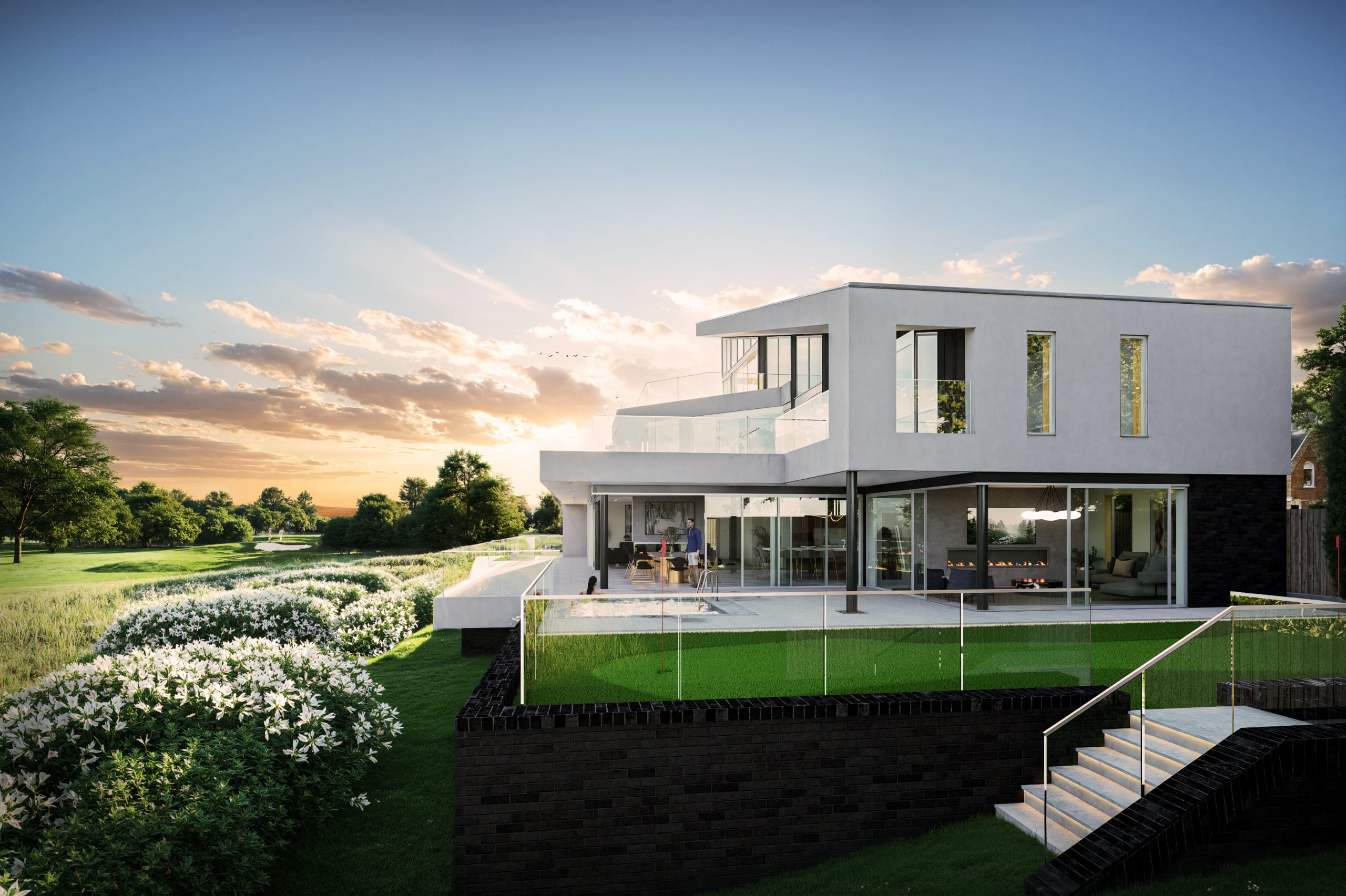 Modern white two-story residence with glass balconies, outdoor patio, putting green, and landscaped garden at sunset