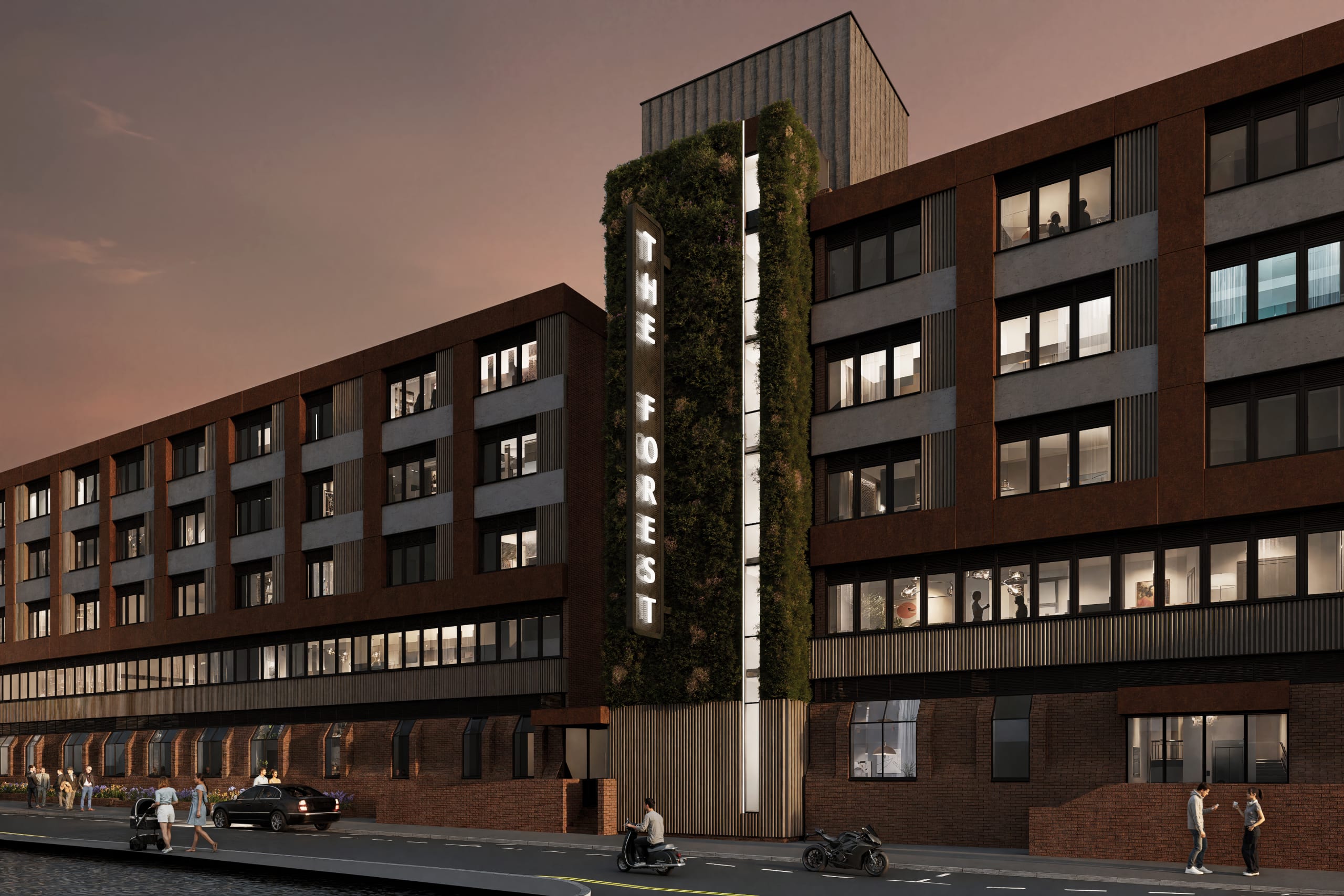 The Forest mixed-use development at dusk featuring vertical green wall, illuminated signage, and modern brick facade