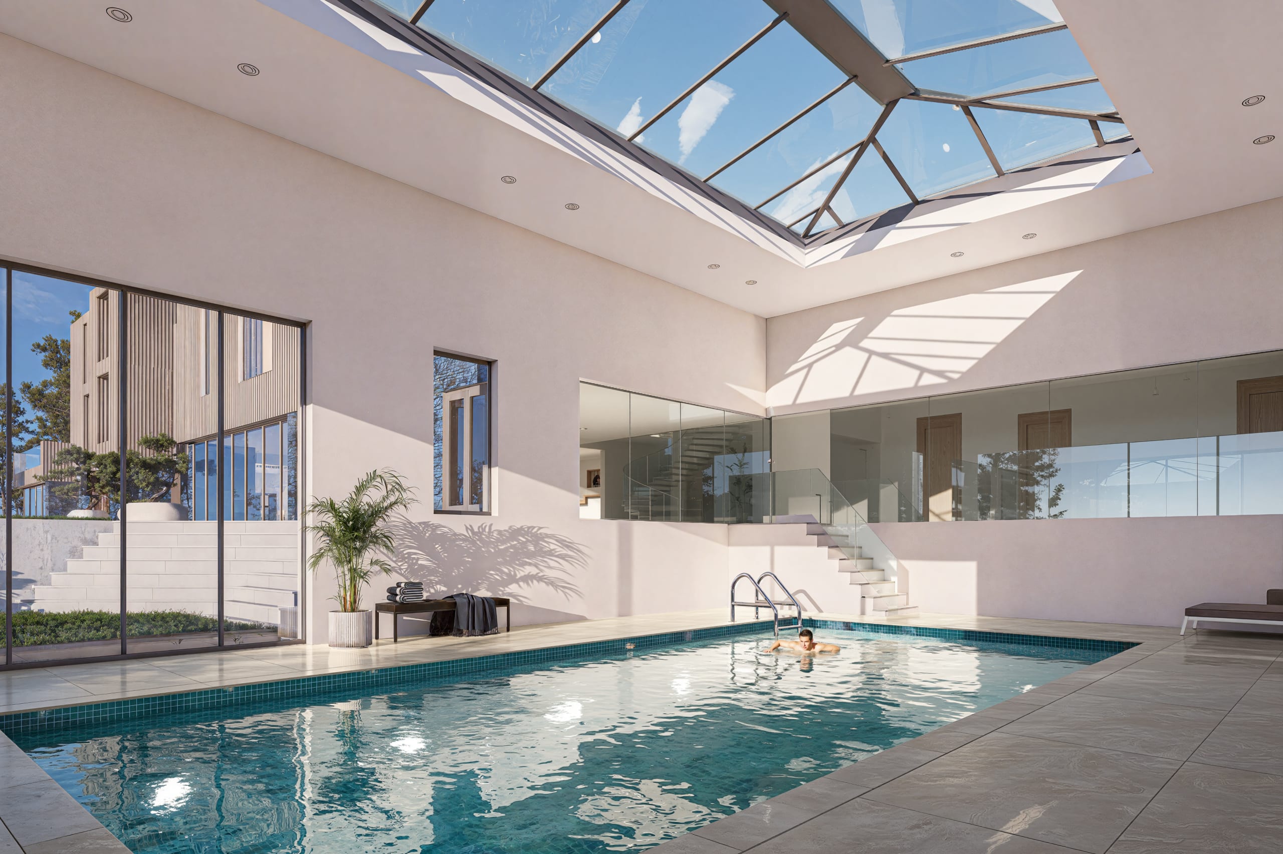 Indoor swimming pool with large geometric skylight, modern white walls, glass railings, and person swimming in turquoise water