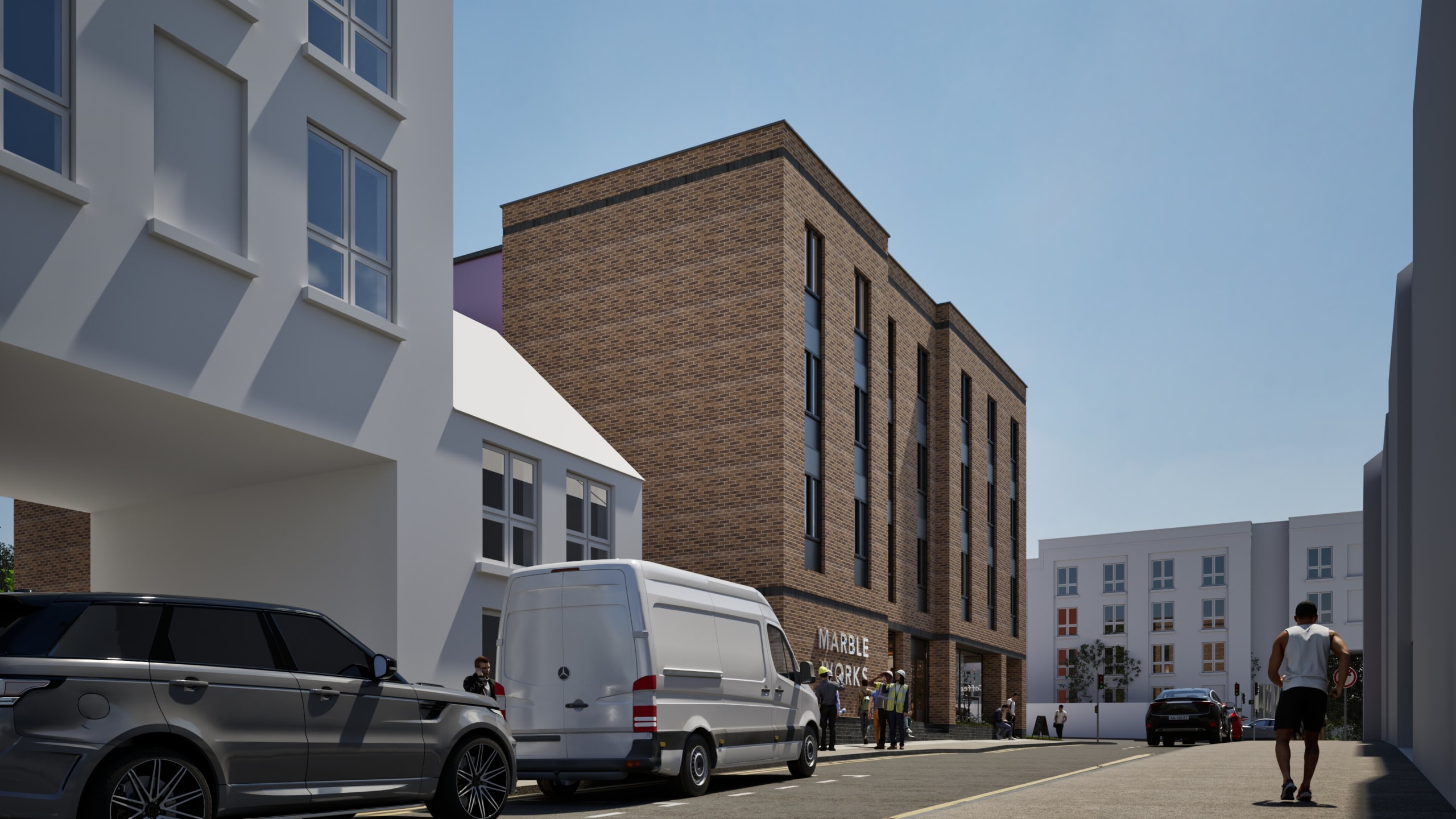 Modern brick building with Marble Works signage alongside white residential buildings, street view with parked vehicles